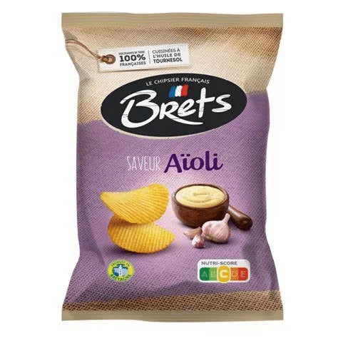A 125g bag of Brets Aïoli Chips by Twice as Sweet (France), labeled Saveur Aïoli, features ridged chips, aioli sauce, and garlic on a purple front with a French flag and Nutri-Score label.