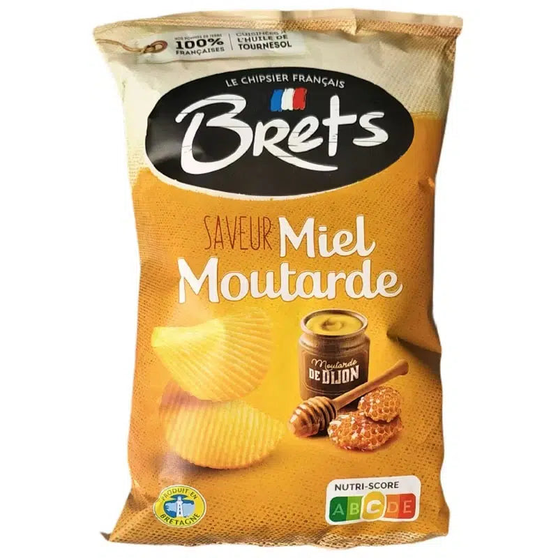 A 125g bag of Twice as Sweet Brets Honey Mustard Chips (France) with wavy chips, a honey dipper, and Dijon mustard jar on a yellow background. Nutri-Score label displayed at the bottom right.