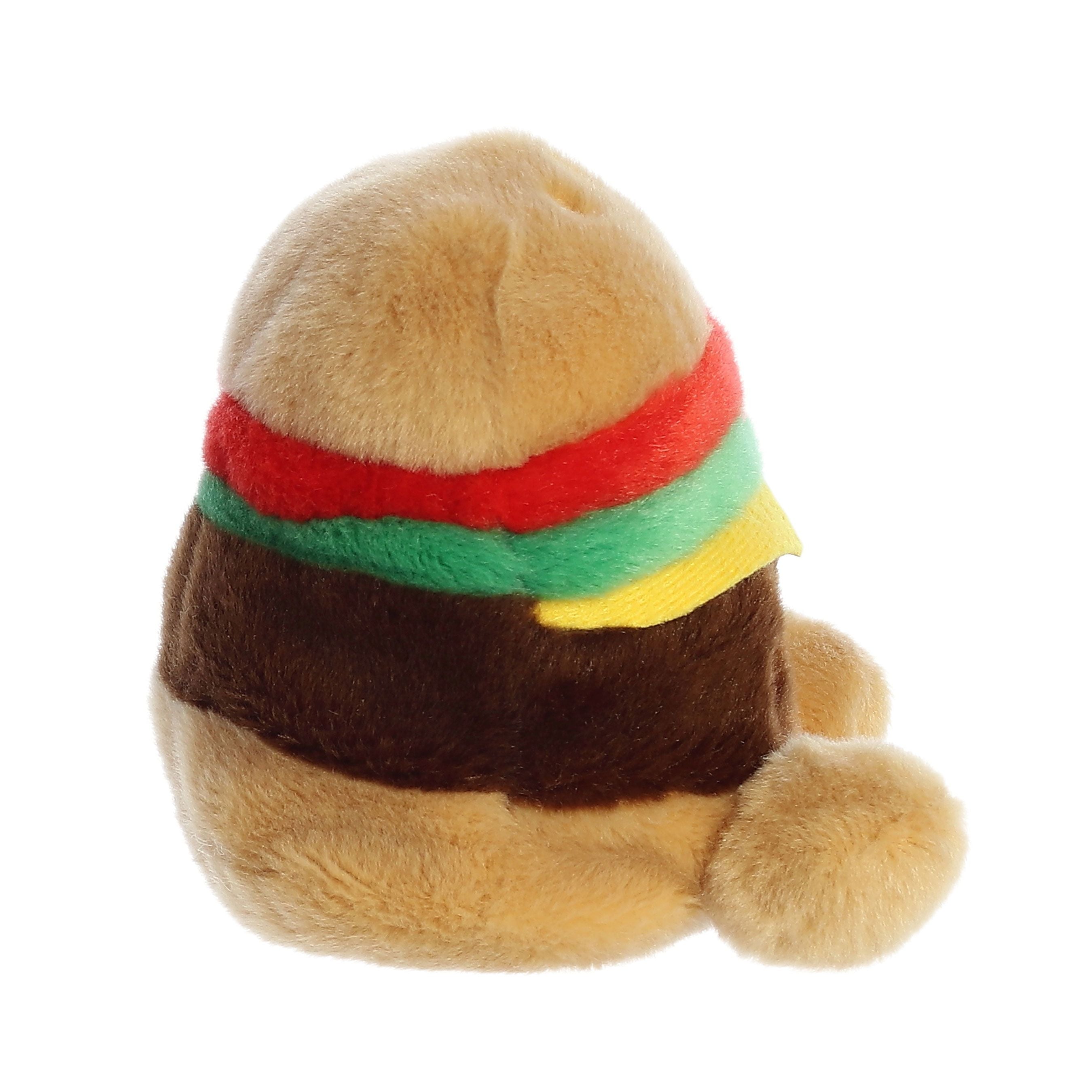 The Palm Pal Charles Cheeseburger plush by Twice as Sweet features fuzzy tan, brown, red, green, and yellow layers for the bun, patty, tomato, lettuce, and cheese. Shown from a side angle on a white background.