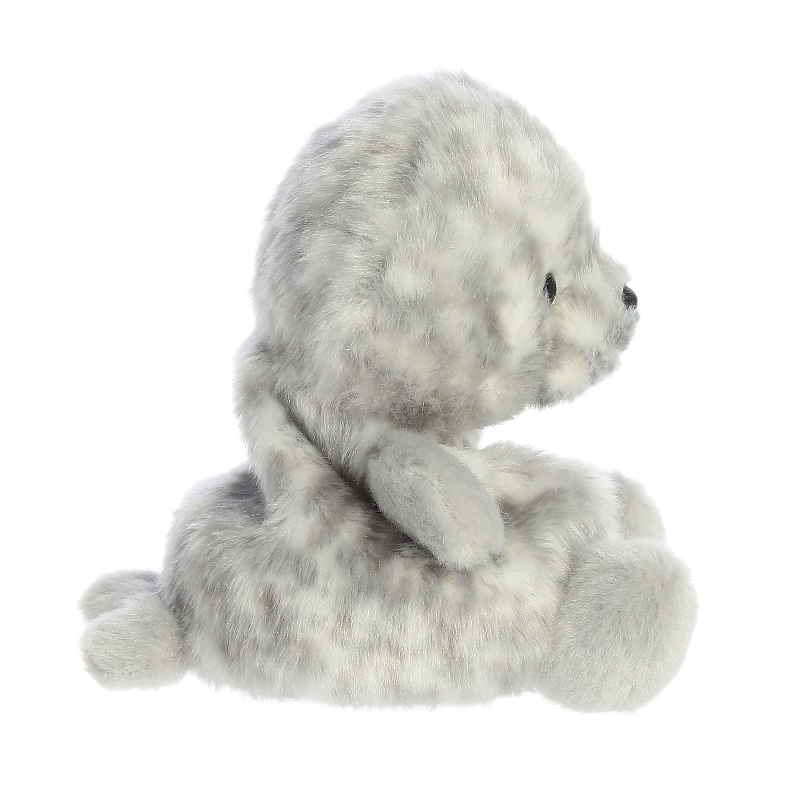 The Twice as Sweet Palm Pal Marina Harbour Seal is a soft, gray and white spotted plush baby seal, shown in profile sitting upright with flippers out and small black eyes.