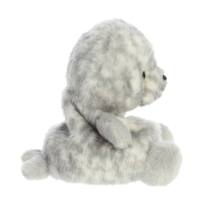 The Twice as Sweet Palm Pal Marina Harbour Seal is a soft, gray and white spotted plush baby seal, shown in profile sitting upright with flippers out and small black eyes.
