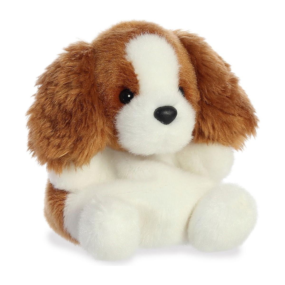 The Twice as Sweet Palm Pal Lady Spaniel is a palm-sized plush toy dog with floppy brown ears, a white face and body, and a brown patch over one eye, sitting upright against a white background.