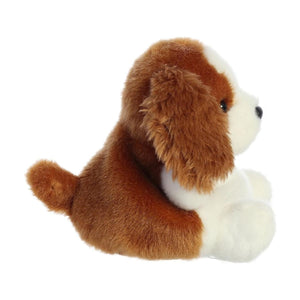 The Twice as Sweet Palm Pal Lady Spaniel is a palm-sized plush toy dog with brown fur on its back, ears, and tail, and white fur on its face, chest, and paws. It sits upright facing right against a white background.