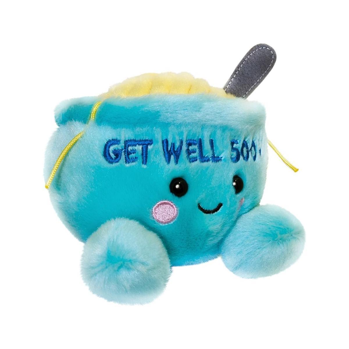 The Twice as Sweet Palm Pal Welly Chicken Soup is a blue bowl plush with a smiling face, pink cheeks, GET WELL SOU... embroidery, yellow fabric soup inside, and a plush spoon for extra comfort.