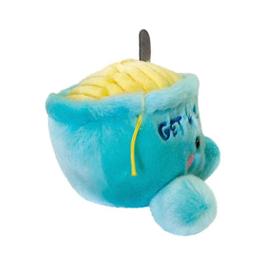 Twice as Sweet’s Palm Pal Welly Chicken Soup is a blue cup plush with yellow noodles, a soft coin, embroidered blue text, two round feet, and a smiling face.